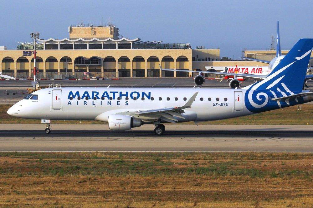 A Marathon Airlines Embraer parked at a terminal stand
